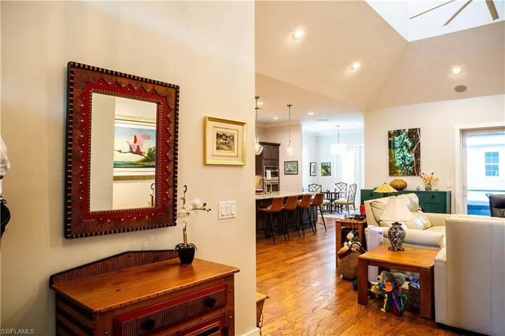 Living room with light wood-type flooring, vaulted ceiling, and recessed lighting