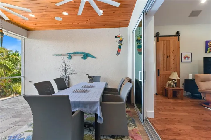 Dining room featuring a barn door, recessed lighting, a ceiling fan, wood ceiling, and a textured wall