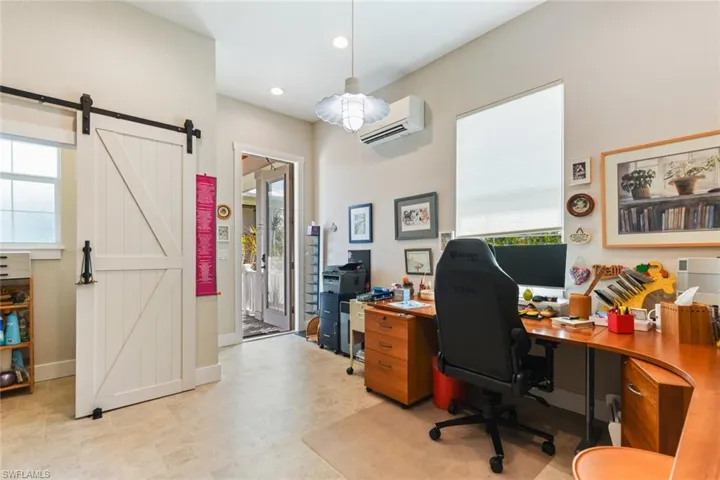 Office space featuring a wall mounted AC, a barn door, recessed lighting, baseboards, and a ceiling fan