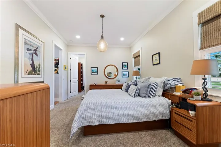 Bedroom with light carpet, crown molding, recessed lighting, and baseboards