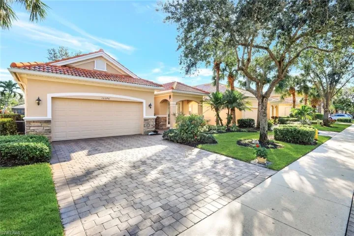 Mediterranean / spanish home featuring a garage and a front lawn