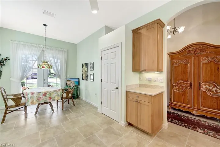 Kitchen with light brown cabinets, pendant lighting, and an inviting chandelier