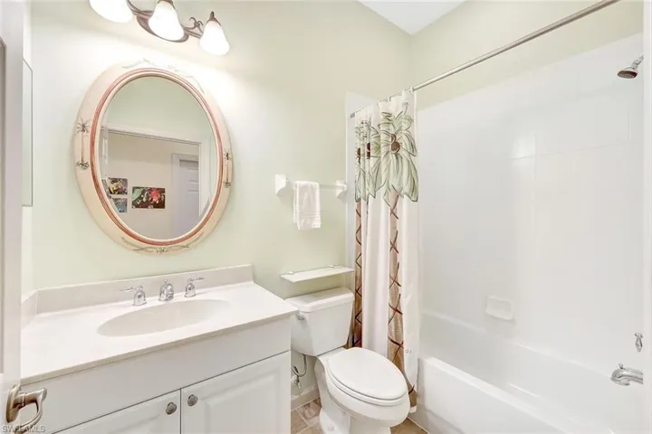 Full bathroom featuring shower / tub combo with curtain, vanity, and toilet