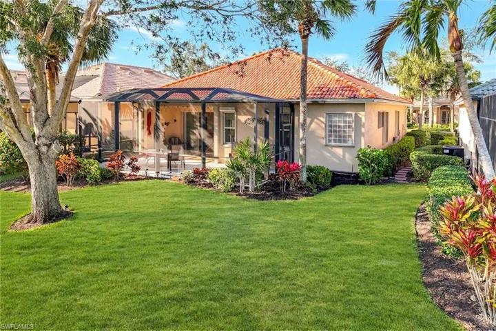Rear view of property featuring a lanai, a patio area, a lawn, and central air condition unit