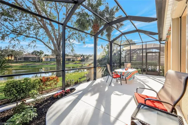 View of patio with a water view and glass enclosure