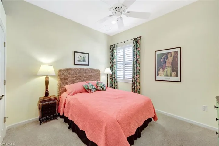 Bedroom with ceiling fan and light carpet
