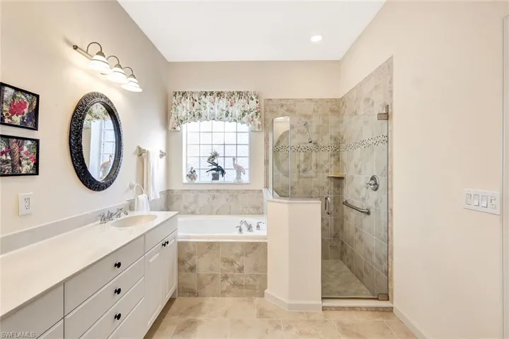 Bathroom with tile patterned floors, separate shower and tub, and vanity
