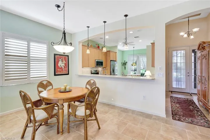 Tiled dining room featuring sink and an inviting chandelier