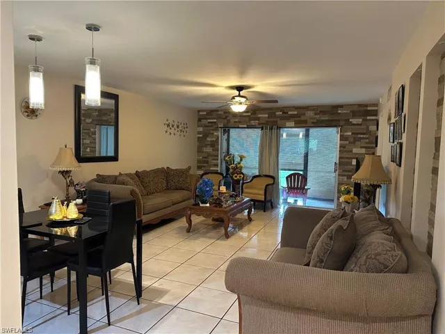 Living room with ceiling fan and light tile patterned floors