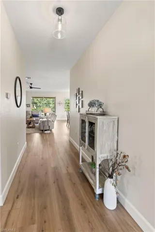 Hallway featuring light wood-type flooring and baseboards