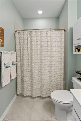 Bathroom featuring vanity, a shower with curtain, and light tile patterned flooring