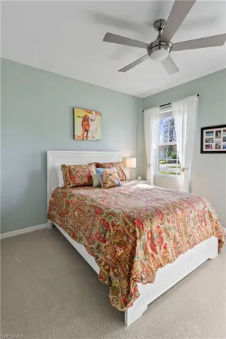 Carpeted bedroom with baseboards and a ceiling fan