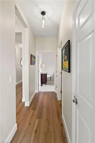 Hall with wood finished floors and baseboards