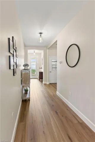 Hall with hardwood / wood-style floors and baseboards