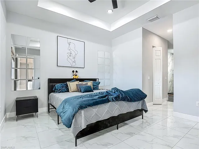 Bedroom featuring a tray ceiling, a ceiling fan, and recessed lighting