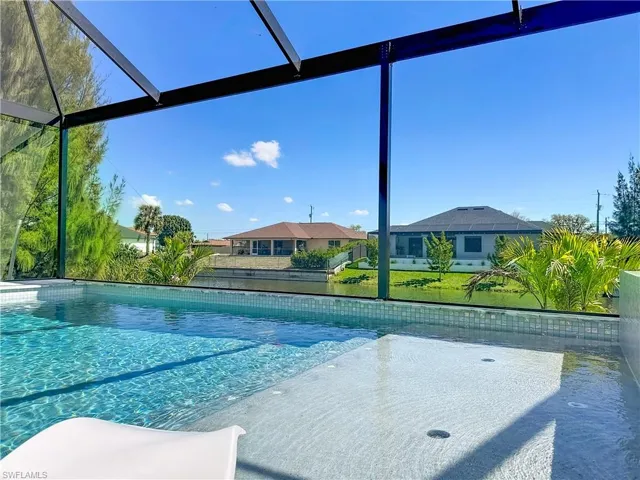 Outdoor pool with a lanai and a lawn