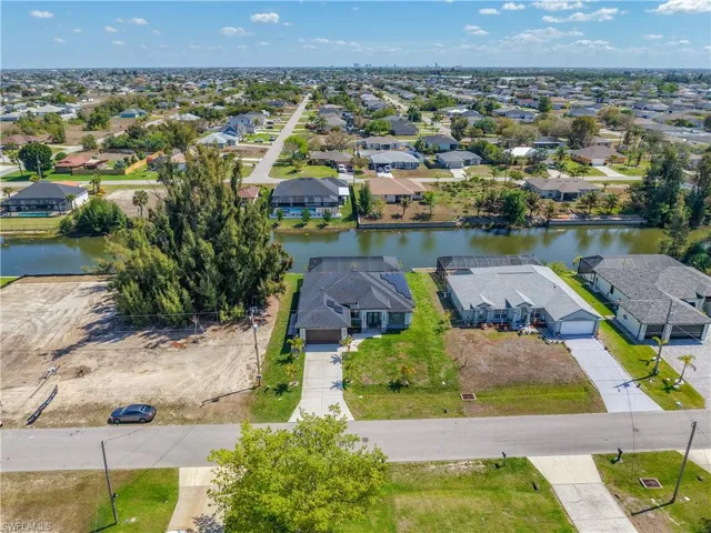 Aerial perspective of suburban area featuring a nearby body of water