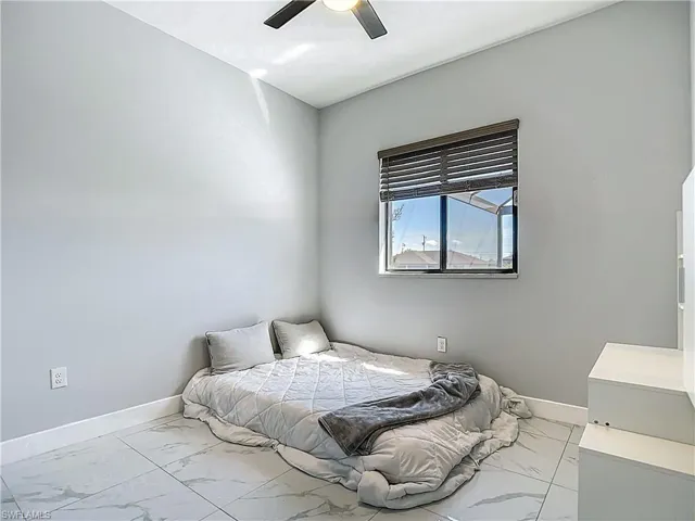 Bedroom with light marble finish floors and a ceiling fan