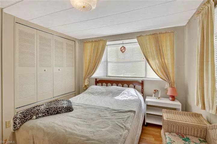 Bedroom with wood finished floors and a closet