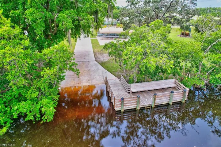 Dock area with a water view and view of wooded area