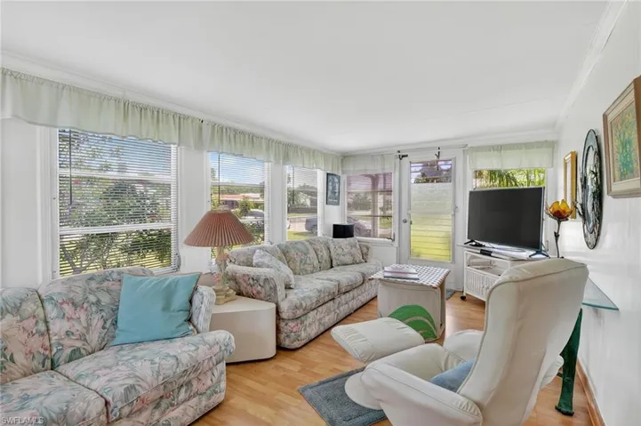 Living room with crown molding and wood finished floors