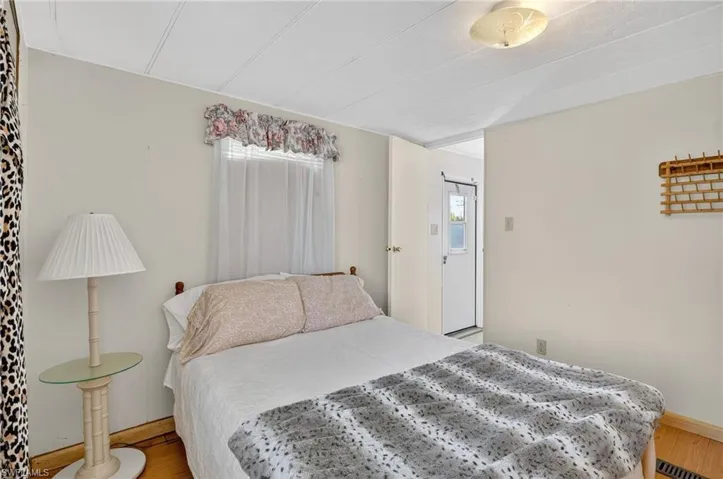 Bedroom with wood finished floors and baseboards