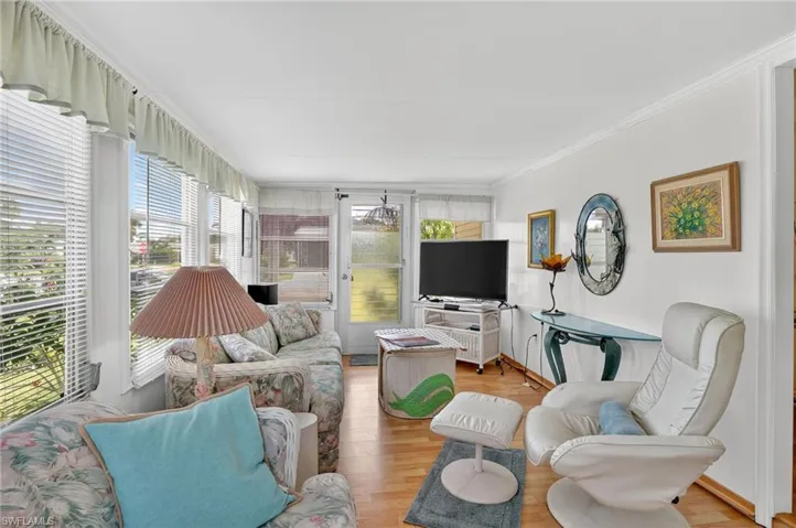 Living area featuring light wood finished floors and crown molding