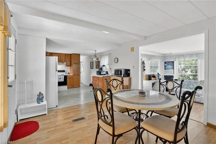 Dining room with beam ceiling and light wood-style flooring