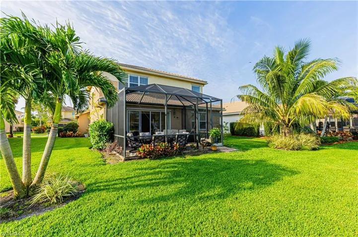 Back of property with a yard and a lanai