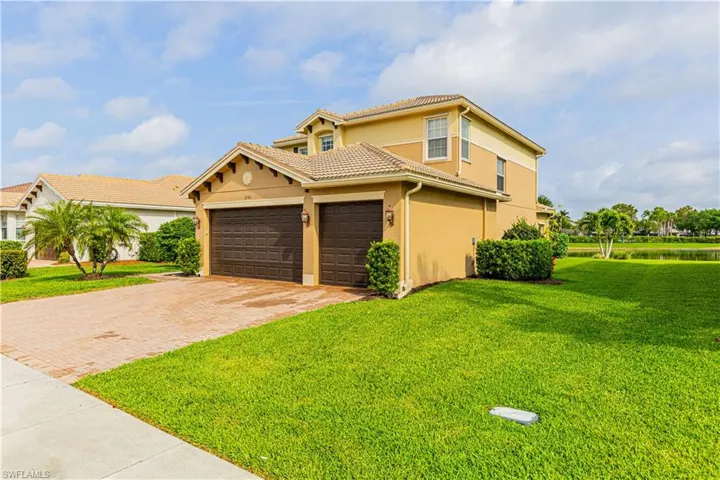 Mediterranean / spanish-style home featuring a garage and a front lawn