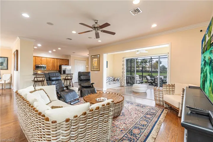 Living room featuring ceiling fan, crown molding, and hardwood / wood-style flooring
