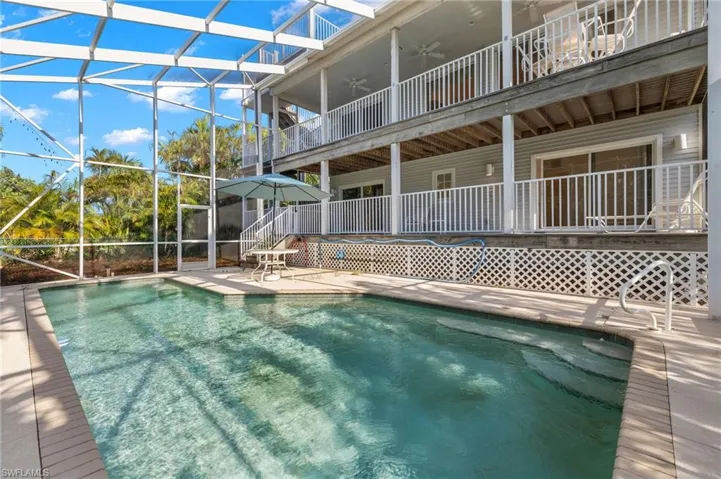 View of swimming pool with glass enclosure and a patio