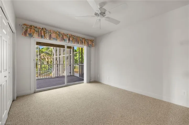 Carpeted empty room with ceiling fan