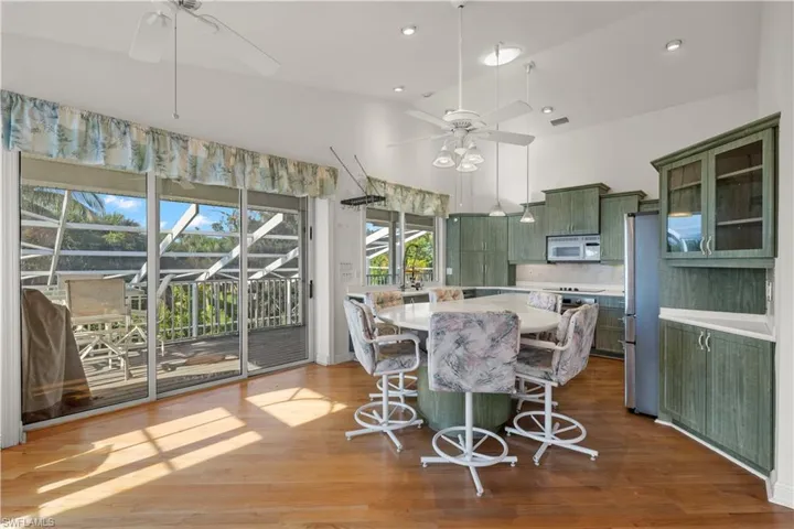 Kitchen featuring hardwood / wood-style floors, backsplash, ceiling fan, and green cabinetry