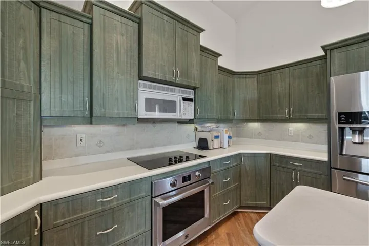 Kitchen featuring light wood-type flooring, tasteful backsplash, and stainless steel appliances