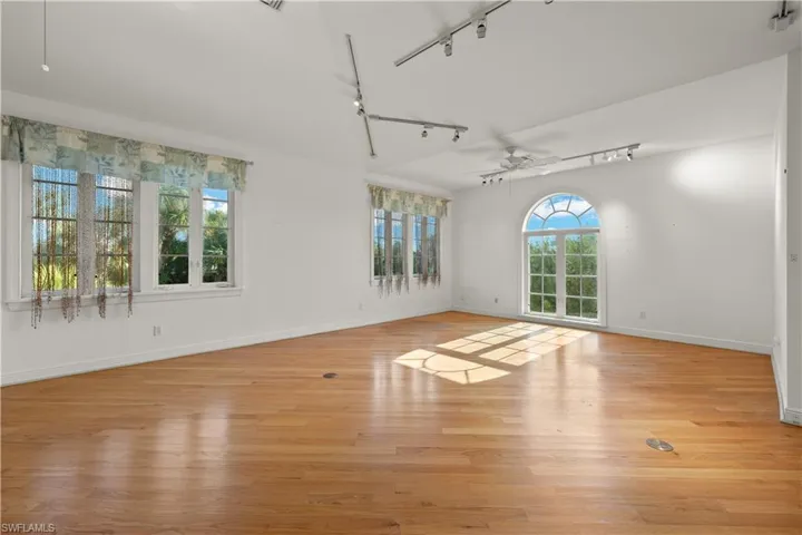 Empty room featuring ceiling fan, light hardwood / wood-style flooring, and track lighting