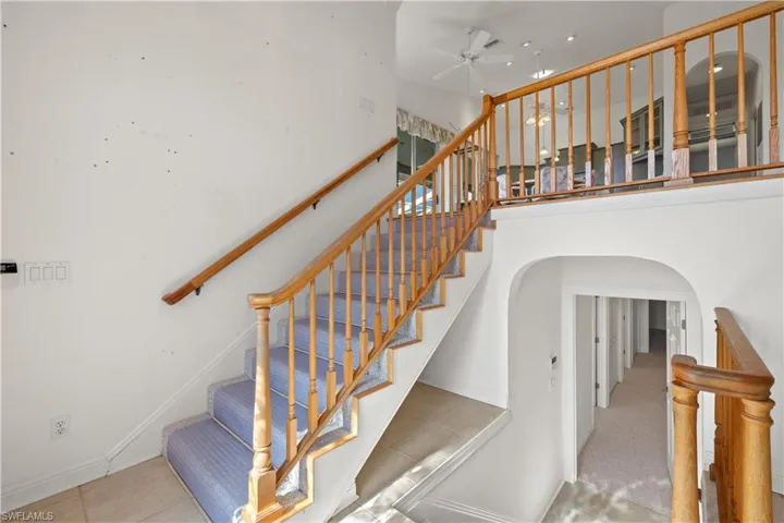 Staircase with ceiling fan and tile patterned floors