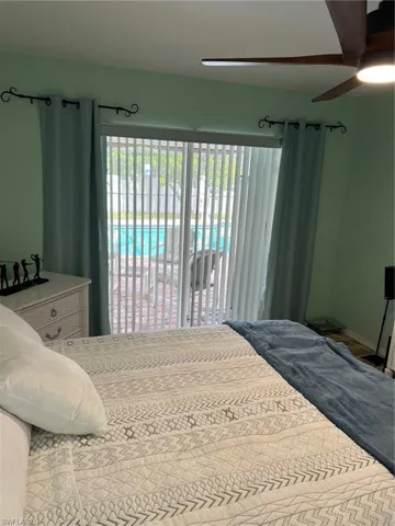 Bedroom featuring access to outside, multiple windows, and ceiling fan