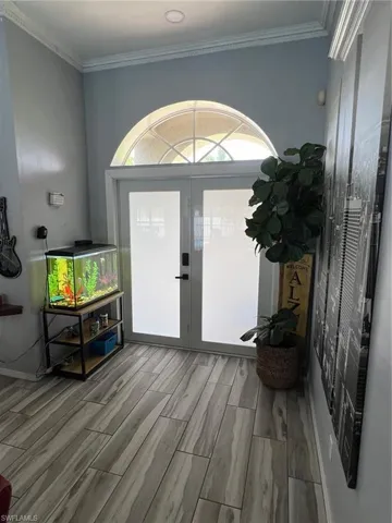 Entrance foyer with wood finish floors and crown molding
