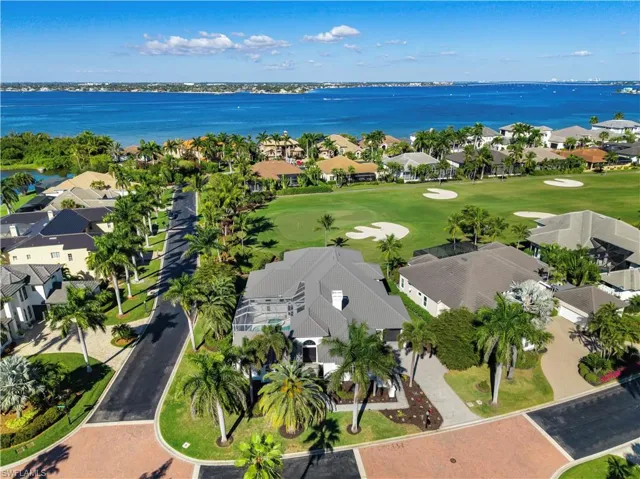 Aerial view of residential area with a large body of water and a golf club