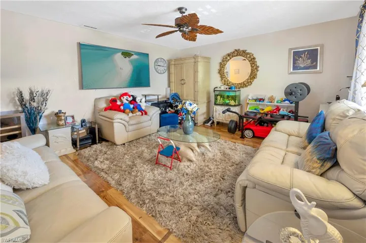 Living room with ceiling fan and Hardwood-style flooring