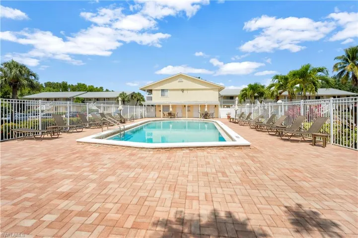 View of pool featuring large deck & view of water feature