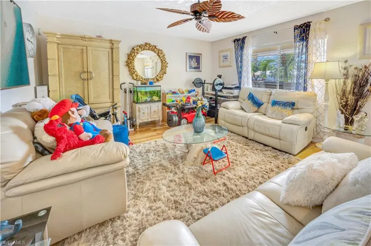 Living room featuring ceiling fan vinyl flooring
