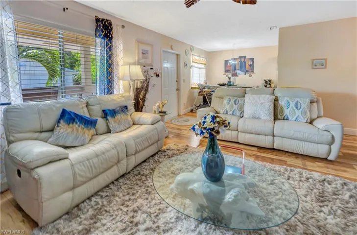 Living room with ceiling fan and hardwood-style floors