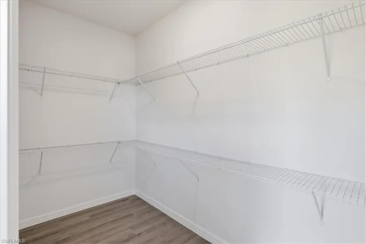 White wire shelving system installed on white walls over wood-finish flooring