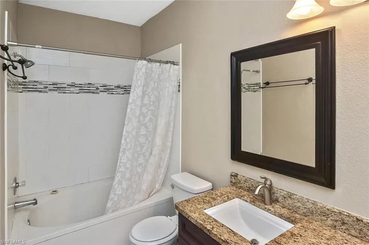 Tub/shower combo with tile surround.