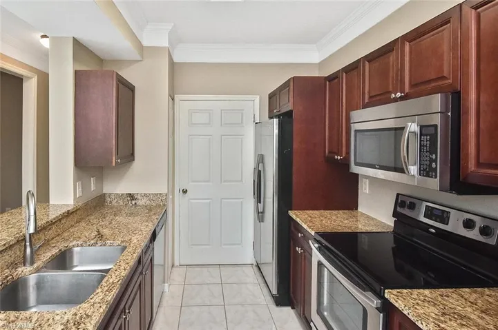 Efficient yet spacious kitchen with stainless appliances, double sink, and pull-down gooseneck faucet.