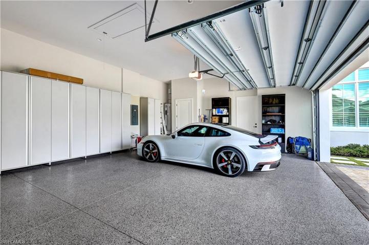 Three Car Garage with entry door, custom cabinets and epoxy floor