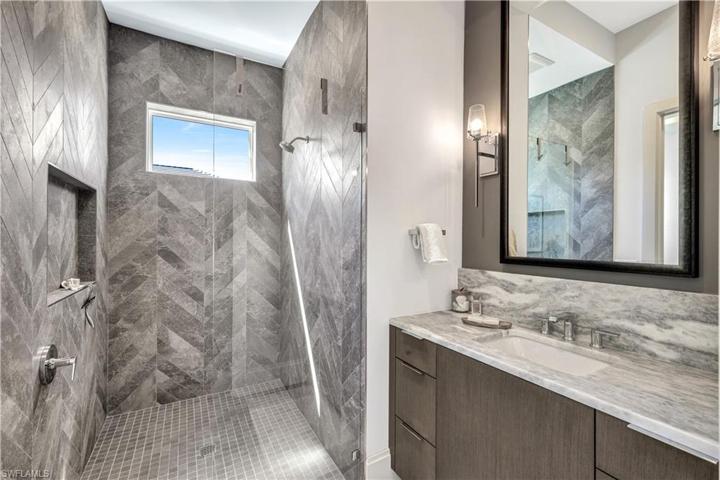 Wood cabinetry and frameless shower enclosure