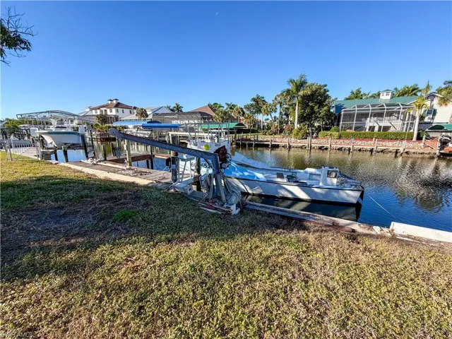 Dock with a water view, a lawn, and boat lift